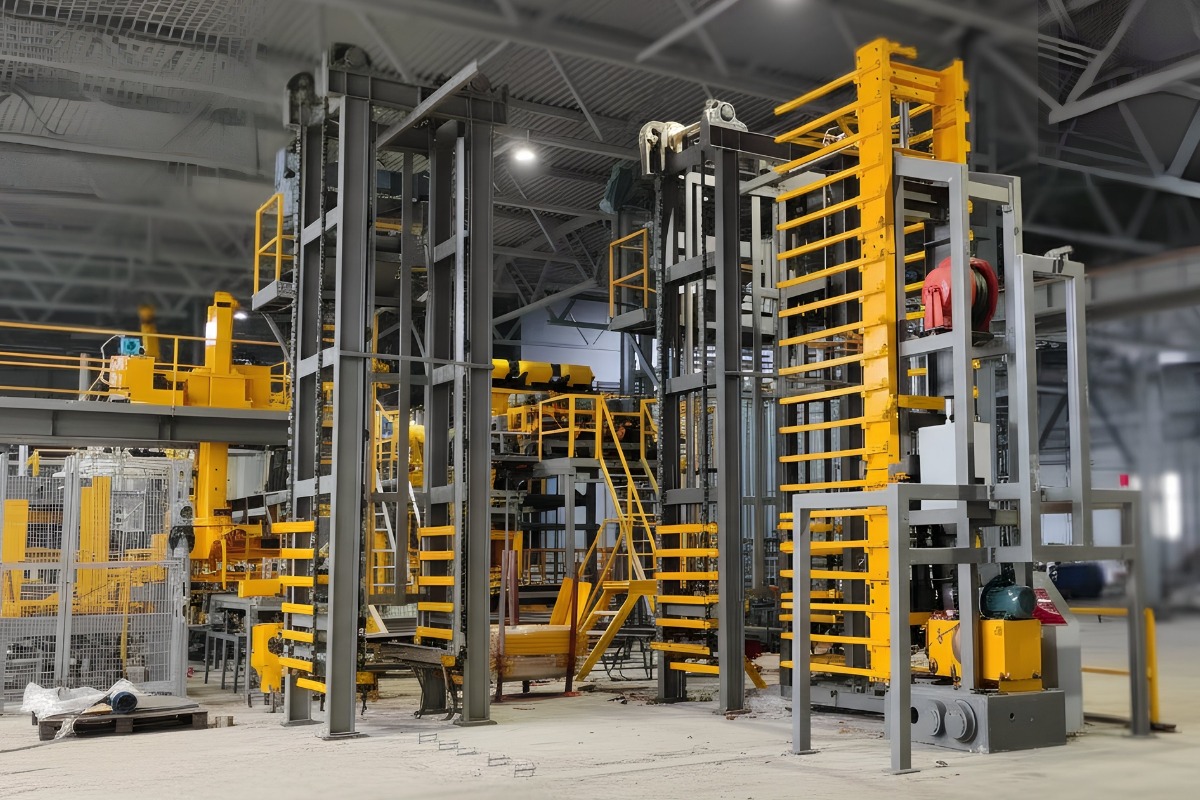 Hercules Series automated concrete block production system overview Automated industrial concrete block production system showing material handling and pallet transfer equipment within a factory environment